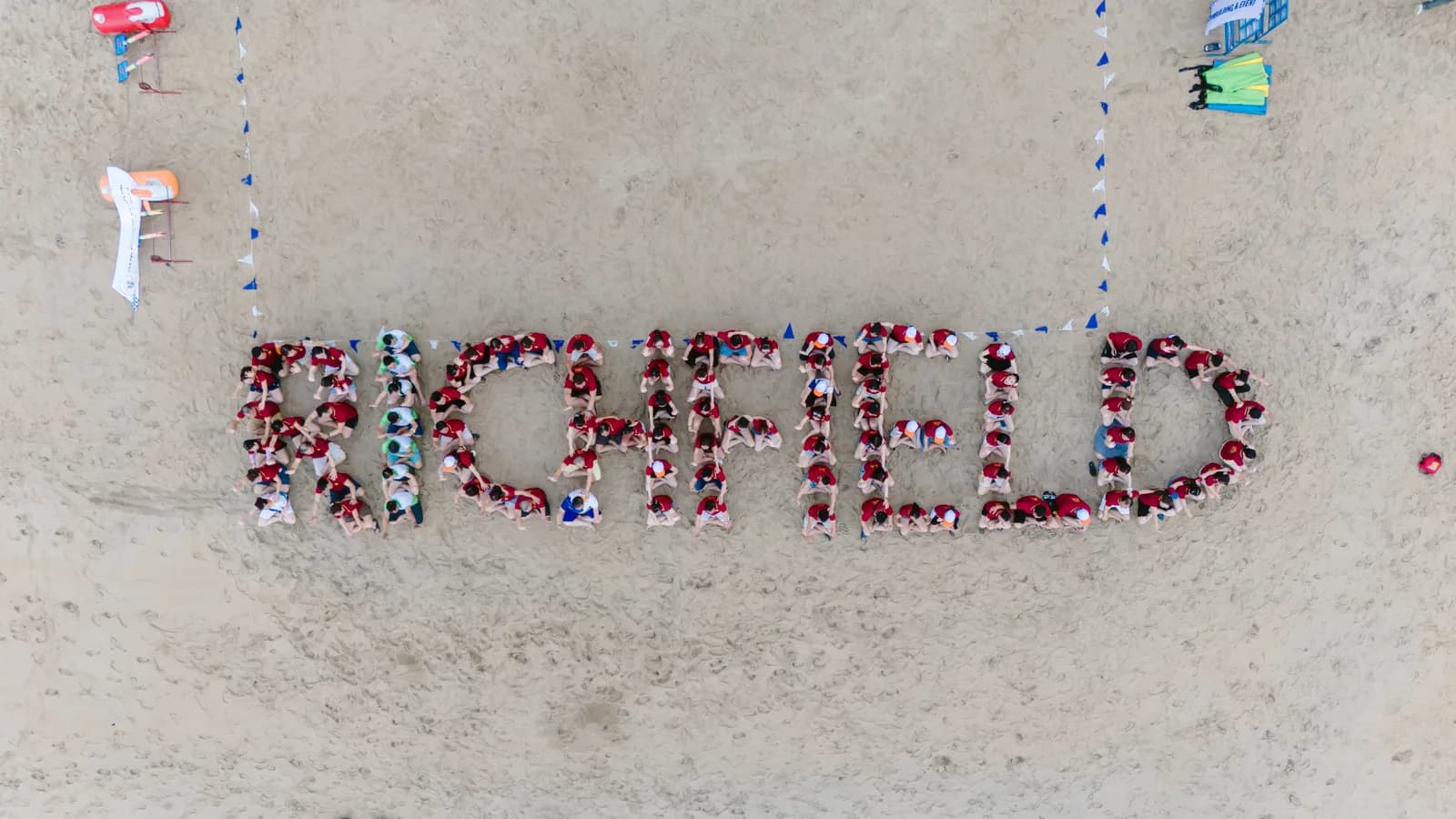 Aerial drone view of the Richfield team spelling out RICHFIELD on the beach.